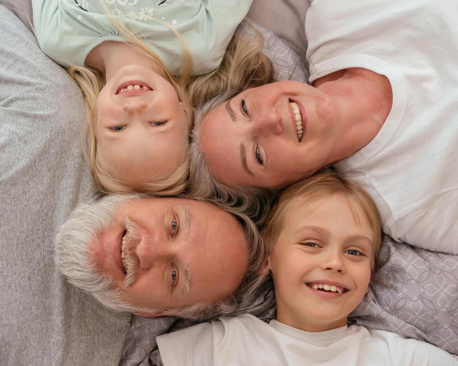 Three generations of a family lying together and laughing.
